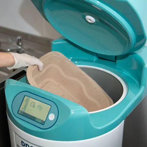 Una enfermera con guantes introduce una cuña de pulpa en el Pulpmatic Flex con la tapa abierta